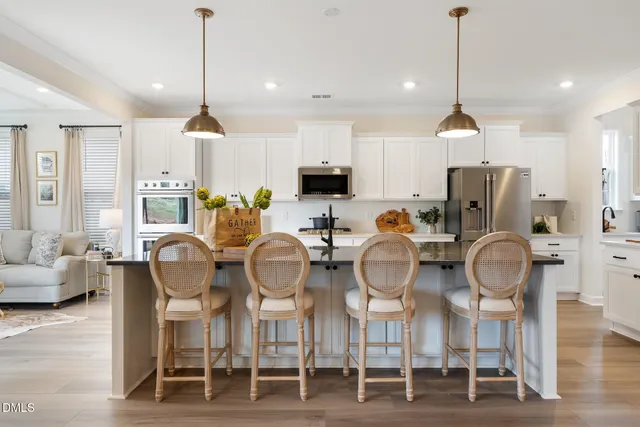 a dining room filled chandelier and wooden floor