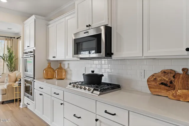 a kitchen with white cabinets and appliances