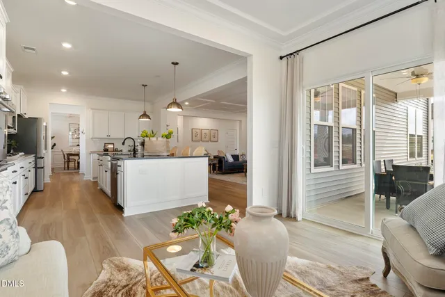 a living room with furniture wooden floor and a kitchen