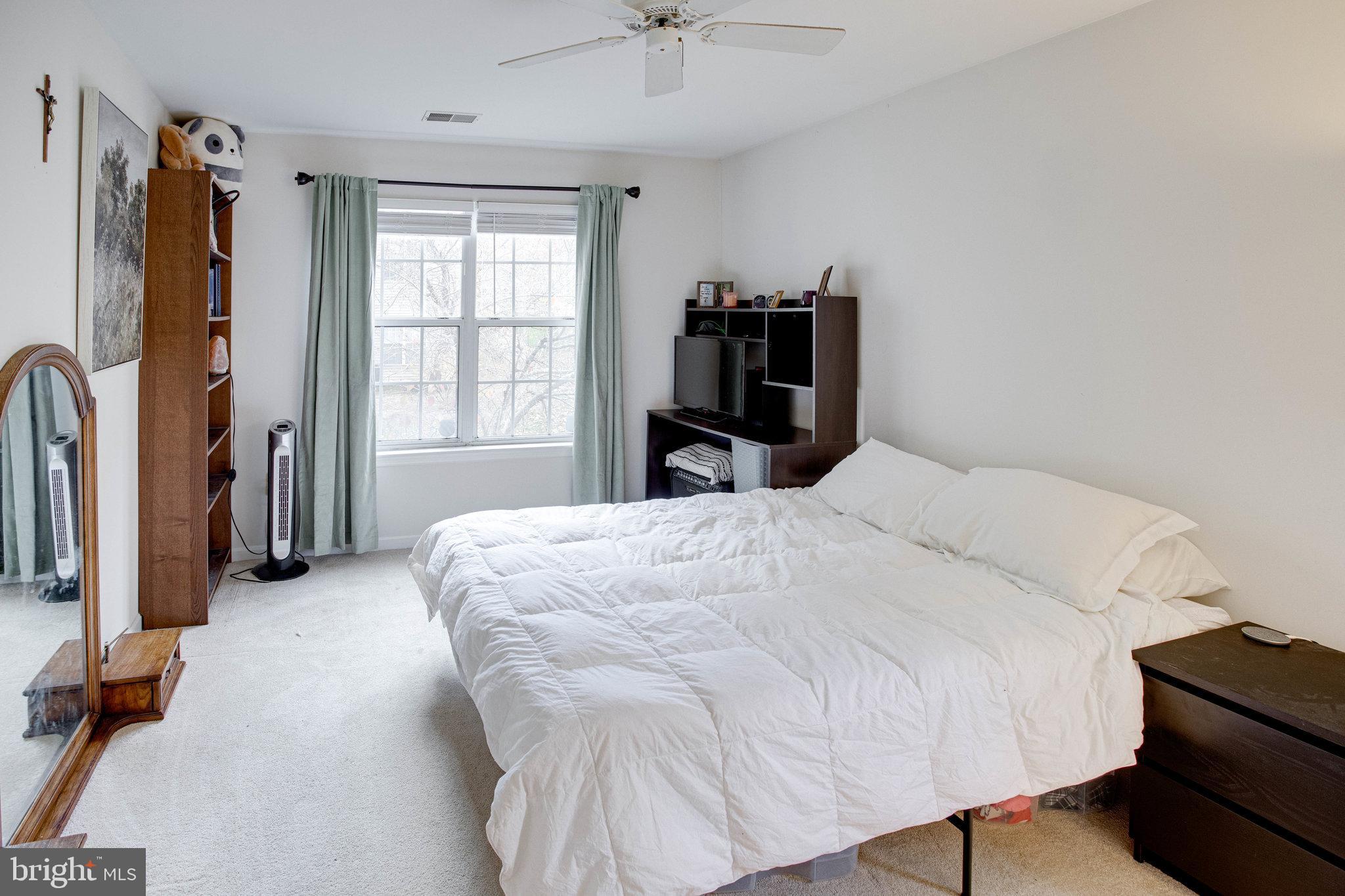 13615 Garfield Place, Unit 203 Woodbridge, VA 22191 - Photo 12 of 25 a large bed sitting in a bedroom next to a window