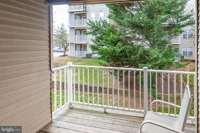 a view of a balcony with a floor to ceiling window and wooden fence