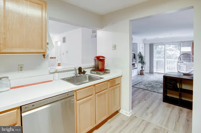 a kitchen with a sink cabinets and wooden floor