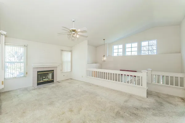 an empty room with windows and a fireplace
