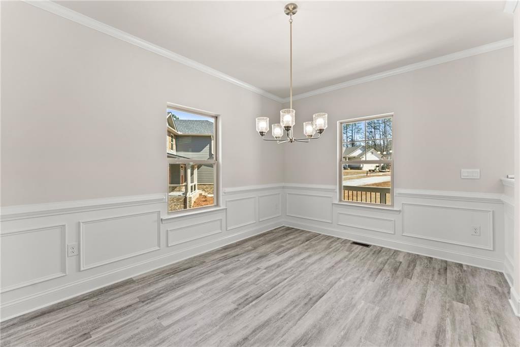 657 Forest Way Cornelia, GA 30531 - Photo 11 of 54 a view of an empty room with a window and wooden floor