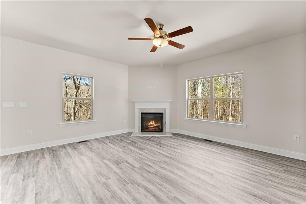657 Forest Way Cornelia, GA 30531 - Photo 13 of 54 a view of an empty room with wooden floor fireplace and a window