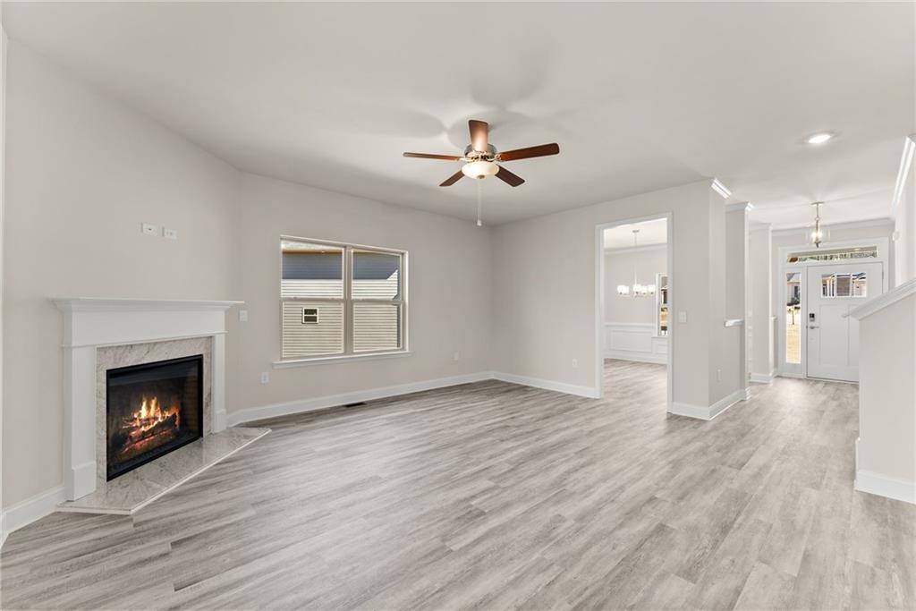 657 Forest Way Cornelia, GA 30531 - Photo 14 of 54 a view of an empty room with wooden floor fireplace and a window