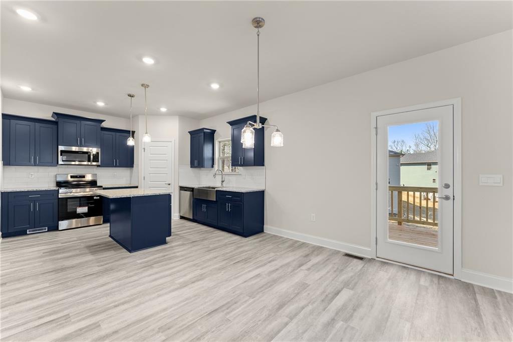657 Forest Way Cornelia, GA 30531 - Photo 16 of 54 a kitchen with stainless steel appliances kitchen island wooden cabinets and granite counter tops