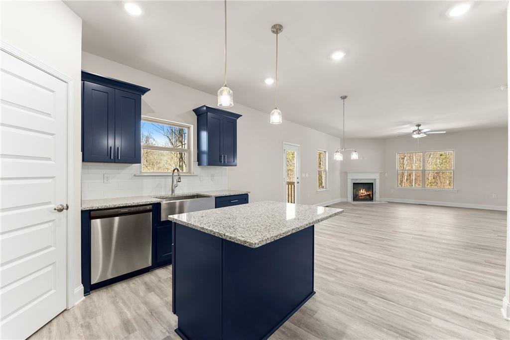 657 Forest Way Cornelia, GA 30531 - Photo 20 of 54 a large kitchen with stainless steel appliances kitchen island granite countertop a stove a sink dishwasher and a refrigerator with wooden floor
