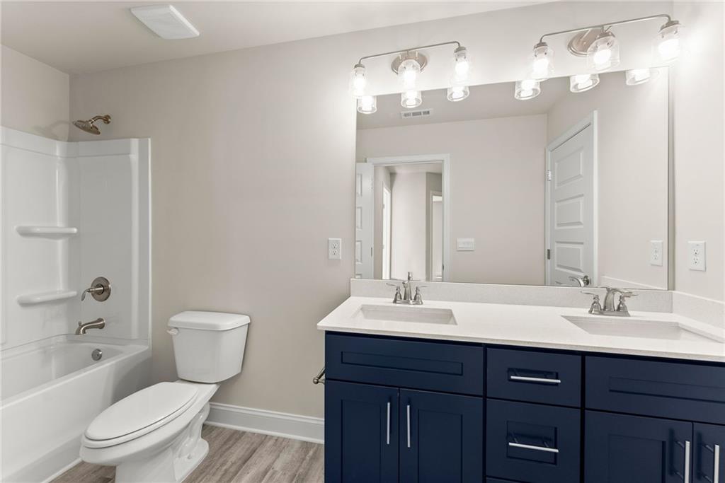 657 Forest Way Cornelia, GA 30531 - Photo 28 of 54 a bathroom with a toilet a sink a mirror a bathtub and vanity