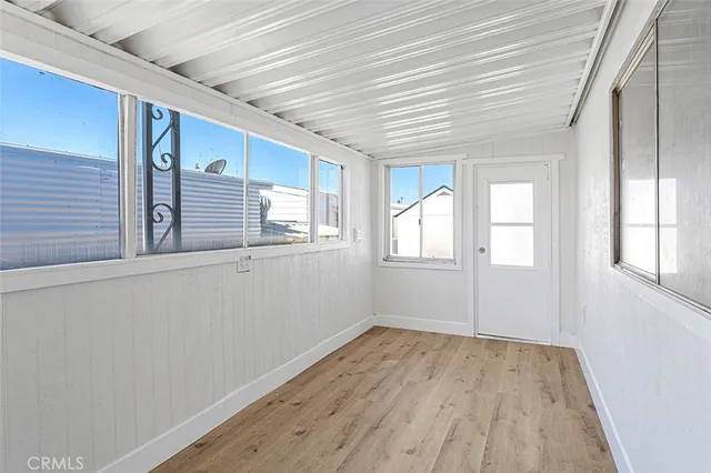 a view of empty room with wooden floor and windows