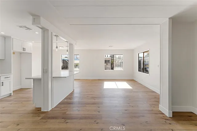 a view of empty room with wooden floor