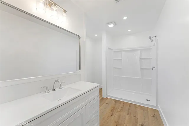a view of an empty room with wooden floor and closet
