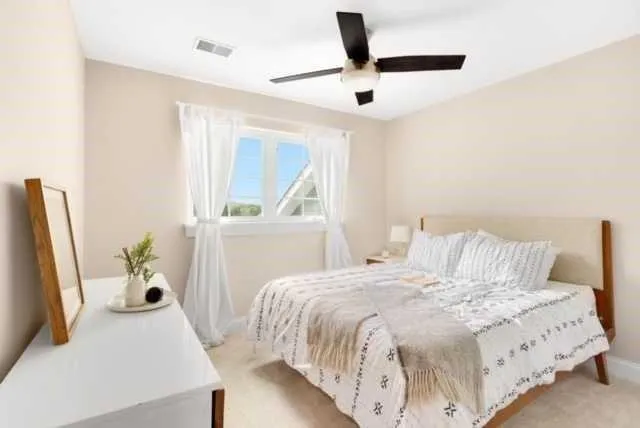 a bedroom with a bed and a large window