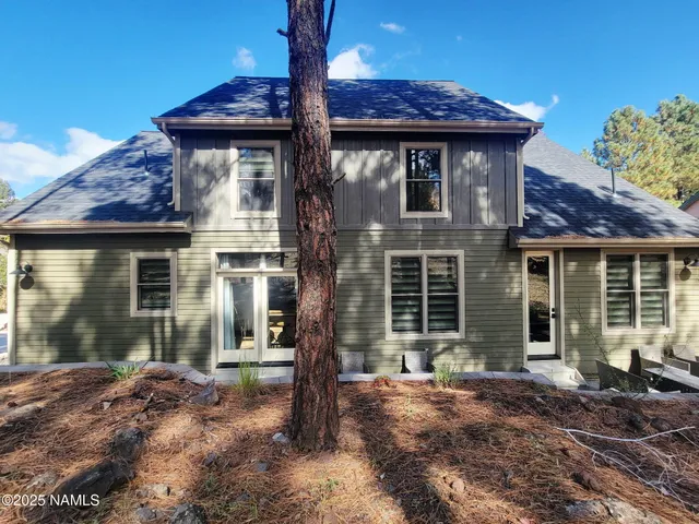 a view of a house with a small yard and floor to ceiling window