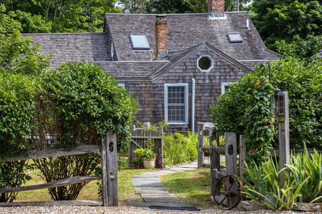 a view of a backyard with chairs and wooden fence