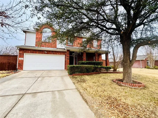 a front view of a house with a yard and trees