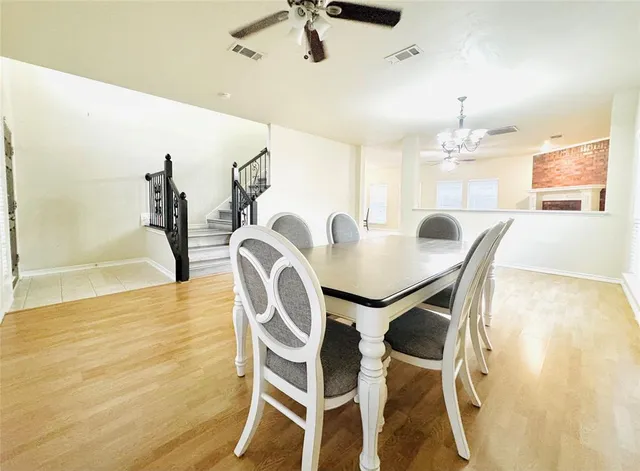 a view of a livingroom with furniture a fireplace wooden floor and chandelier