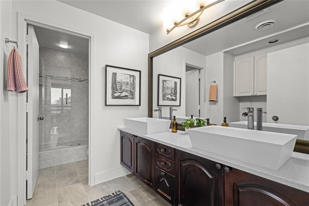 2660 Peachtree Road Northwest, Unit 19A Atlanta, GA 30305 - Photo 12 of 51 a bathroom with a sink double vanity and a shower