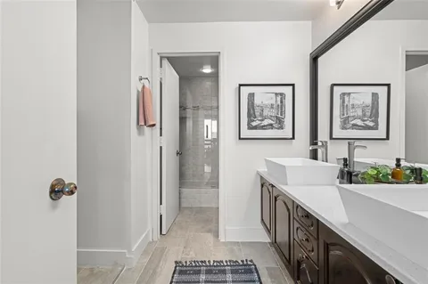 a bathroom with a double vanity sink a mirror and a shower