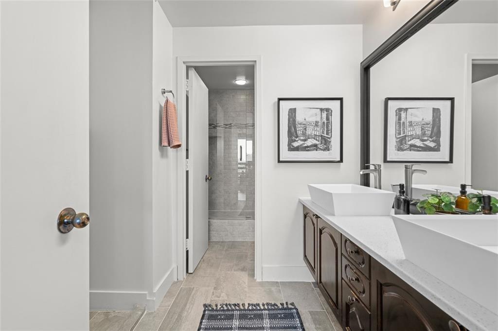2660 Peachtree Road Northwest, Unit 19A Atlanta, GA 30305 - Photo 13 of 51 a bathroom with a double vanity sink a mirror and a shower