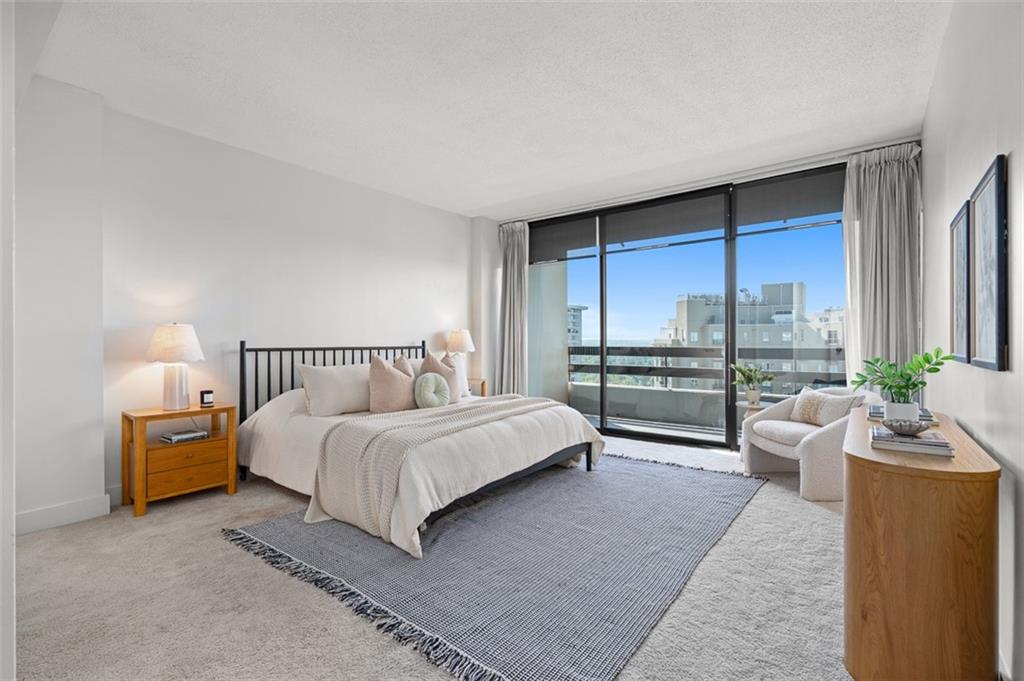2660 Peachtree Road Northwest, Unit 19A Atlanta, GA 30305 - Photo 16 of 51 a spacious bedroom with a bed and a large window