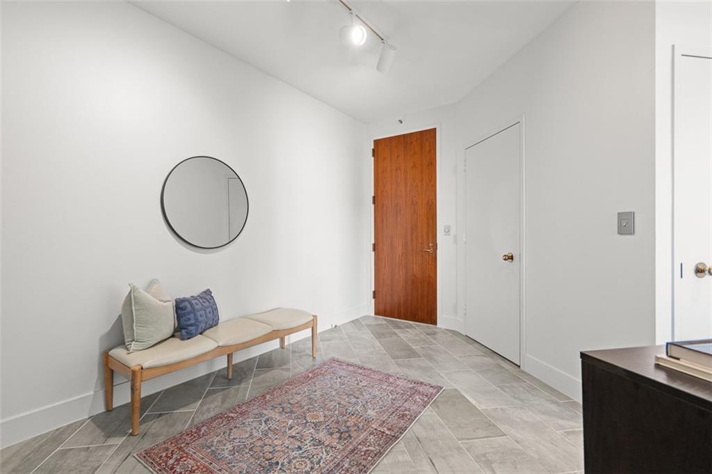 2660 Peachtree Road Northwest, Unit 19A Atlanta, GA 30305 - Photo 6 of 51 a living room with a couch and a mirror