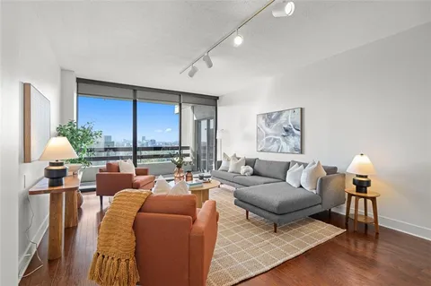 a living room with furniture lamp and a large window