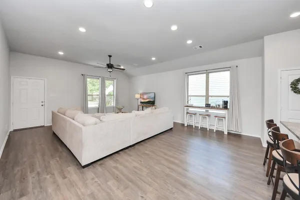 a living room with furniture and a wooden floor