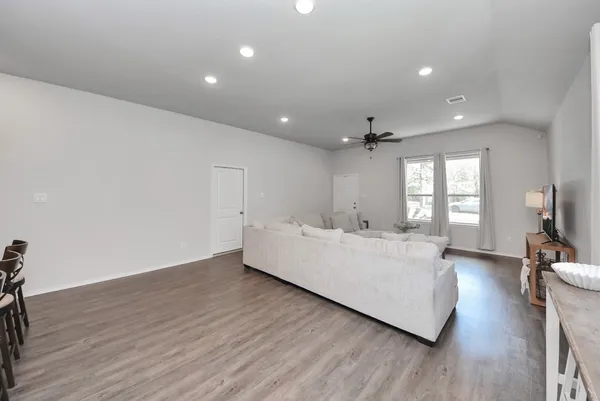 a living room with furniture and wooden floor