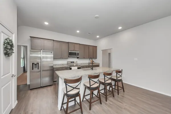 a kitchen with stainless steel appliances a table and chairs