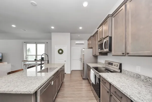 a kitchen with stainless steel appliances granite countertop a sink stove and refrigerator