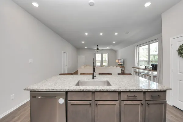 a kitchen with granite countertop kitchen island a sink appliances and cabinets