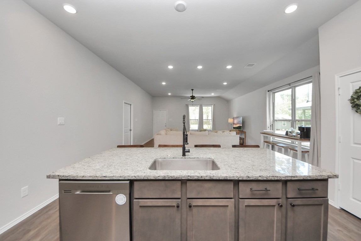 709 Little River Drive Montgomery, TX 77316 - Photo 19 of 40 a kitchen with granite countertop kitchen island a sink appliances and cabinets