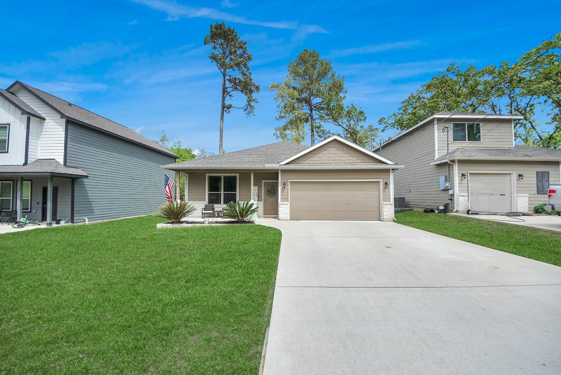 709 Little River Drive Montgomery, TX 77316 - Photo 2 of 40 a front view of a house with a garden and porch