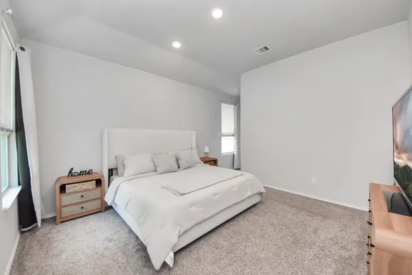 a bedroom with a bed next to a window