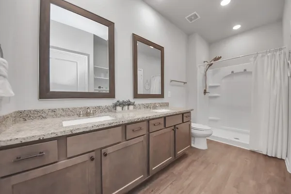 a bathroom with a granite countertop sink mirror vanity and toilet