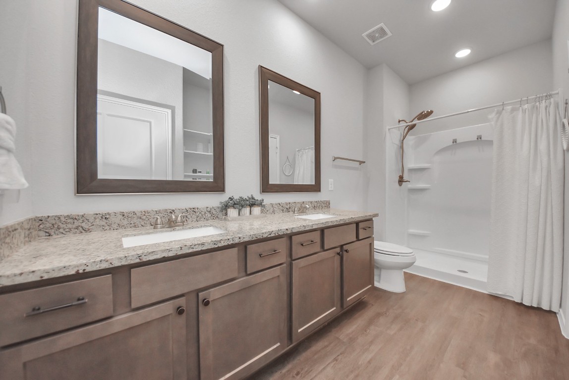 709 Little River Drive Montgomery, TX 77316 - Photo 24 of 40 a bathroom with a granite countertop sink mirror vanity and toilet