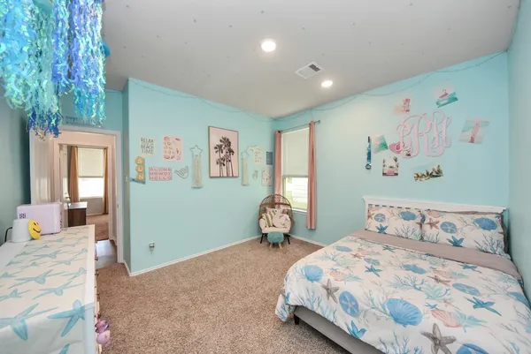 a bedroom with a bed and painting on the wall