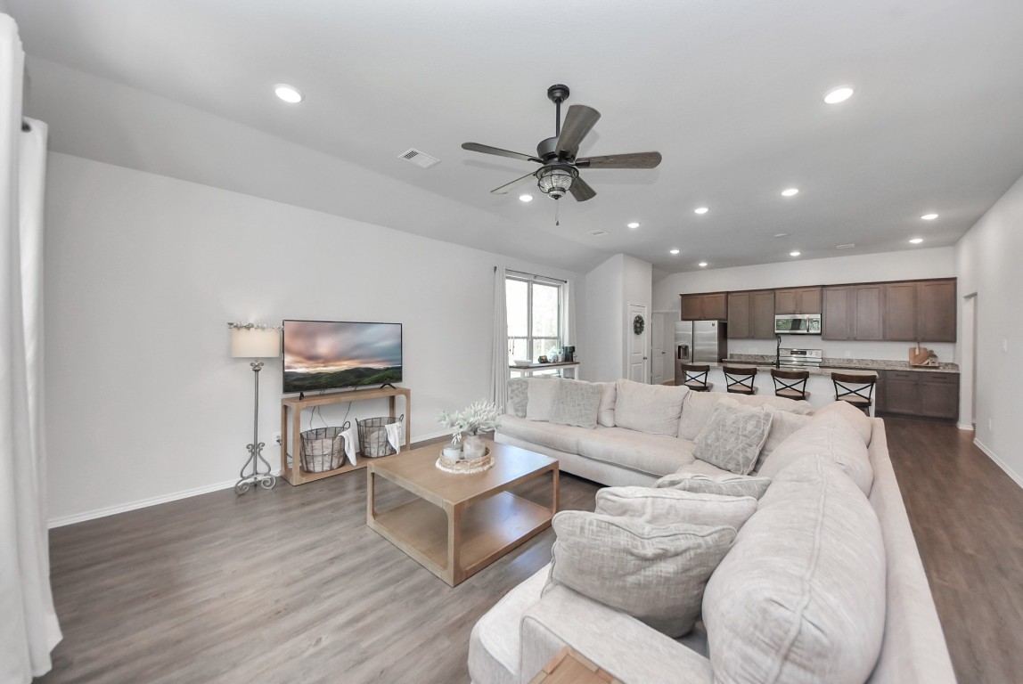 709 Little River Drive Montgomery, TX 77316 - Photo 6 of 40 a living room with furniture a kitchen view and a flat screen tv