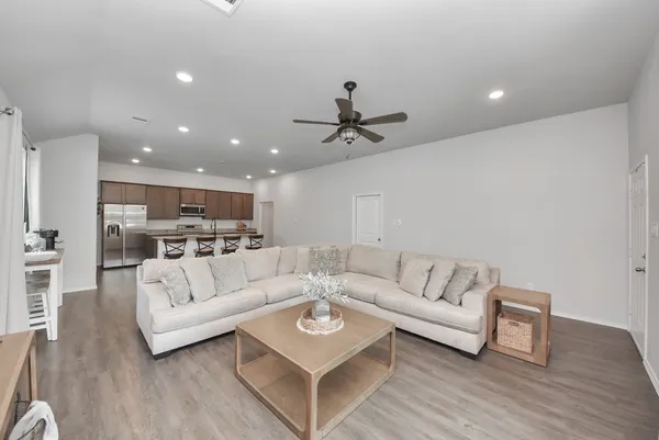 a living room with furniture and a wooden floor