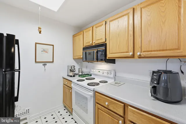 a kitchen with stainless steel appliances wooden cabinets a stove a refrigerator and a sink