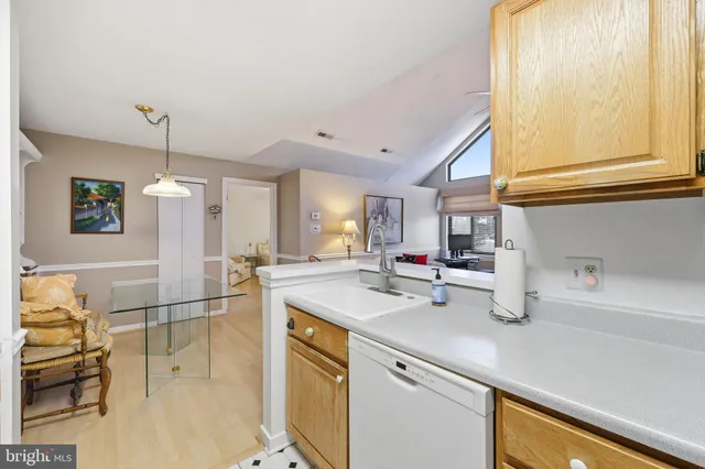 a kitchen with a sink a counter top space and living room area