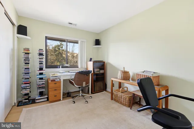 a view of a workspace with furniture and a window
