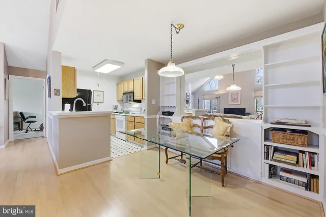 a living room with furniture kitchen view and a wooden floor