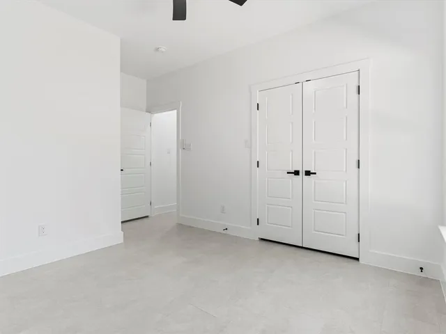 an empty room with white cabinet and mirrors