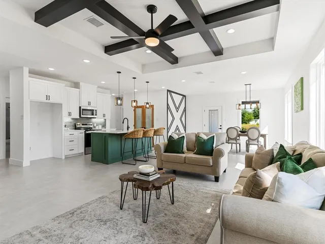 a living room with furniture kitchen view and a chandelier