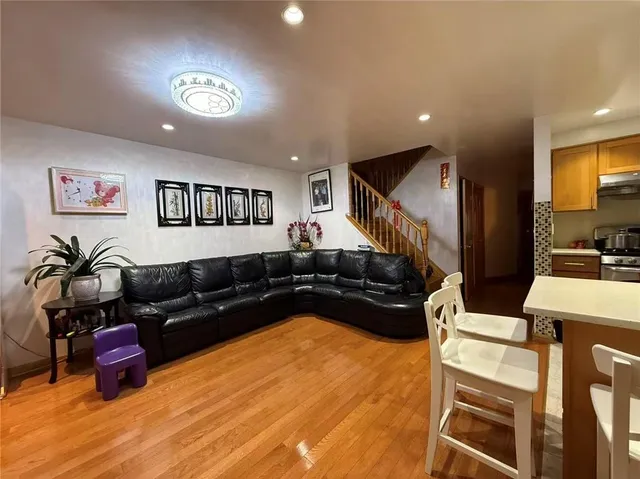 a living room with furniture a large window and flat screen tv