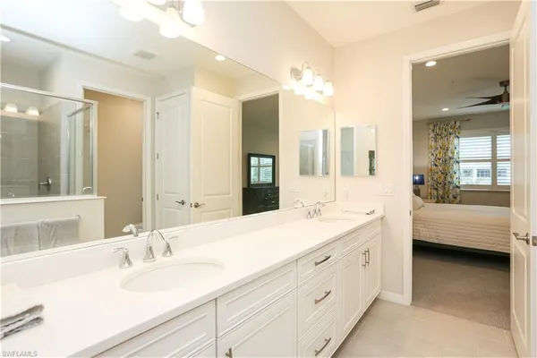 a spacious bathroom with a double vanity sink mirror and bathtub