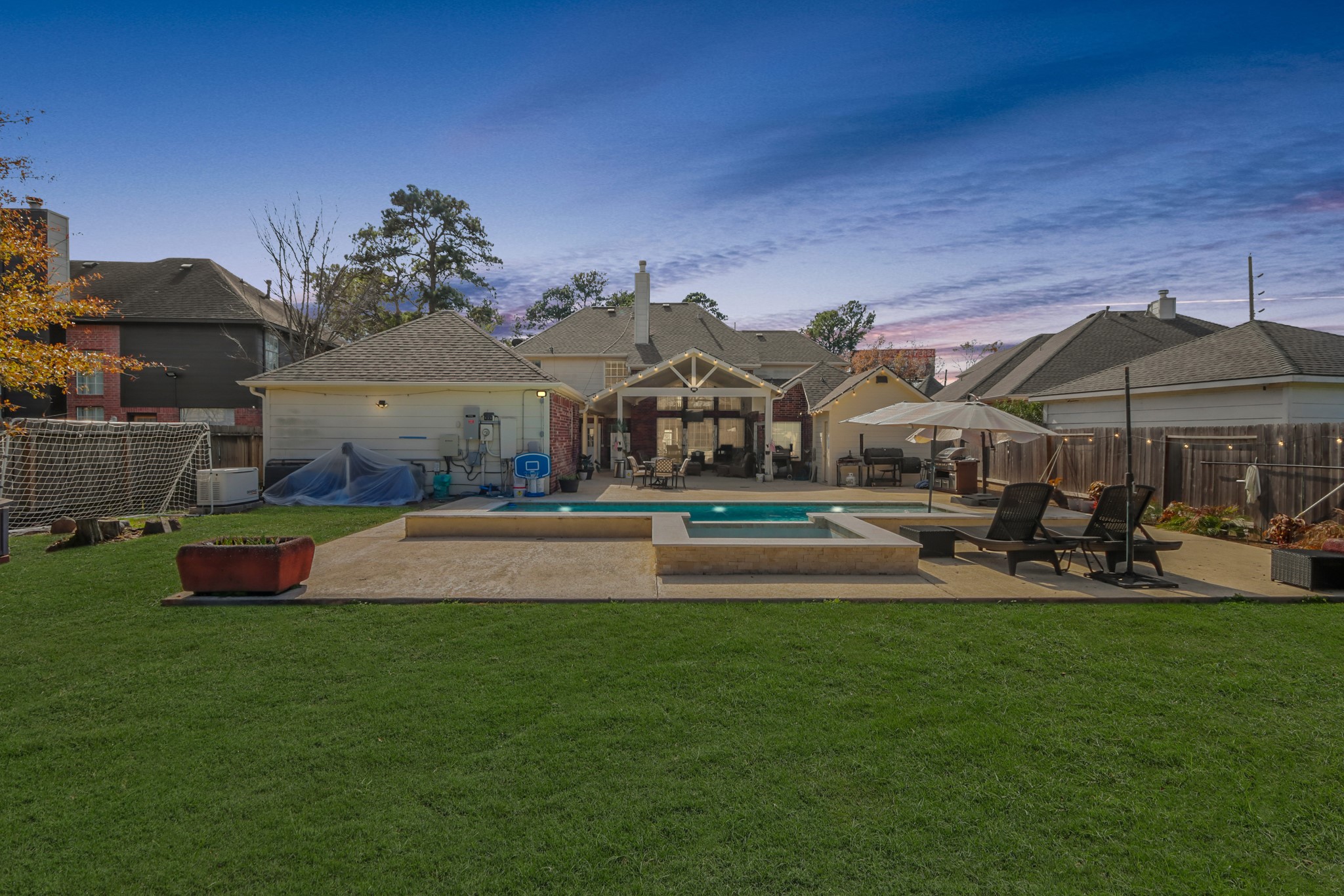 20514 Cannaberry Way Spring, TX 77388 - Photo 34 of 42 Beautifully designed backyard showcasing the pool, spa, and covered outdoor entertaining space, offering the ultimate setup for relaxation and gatherings.