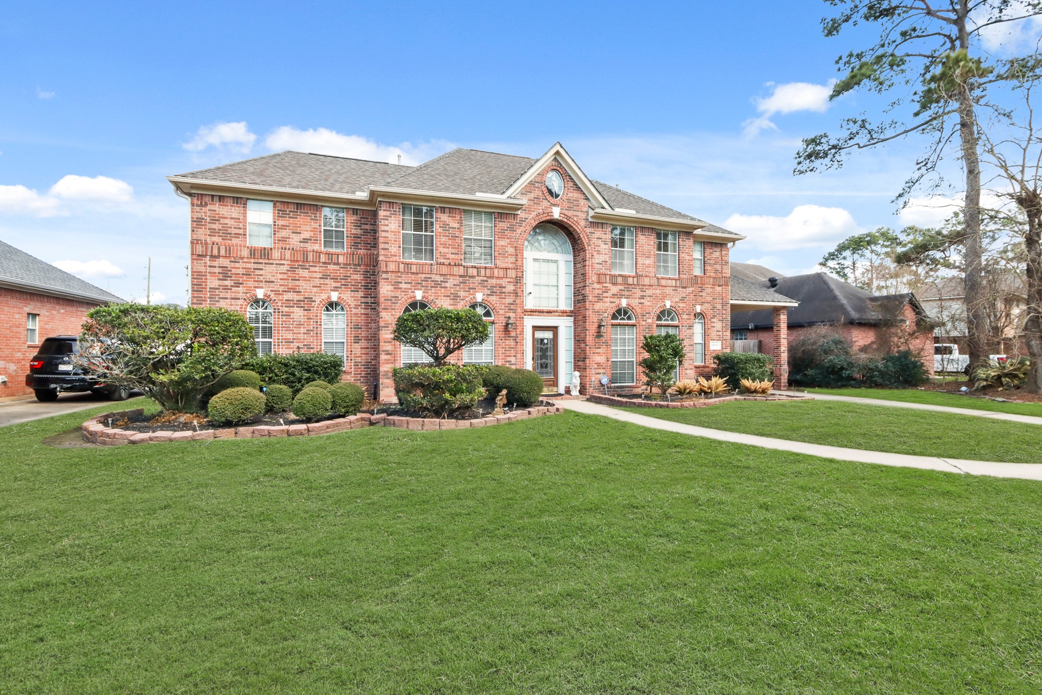 20514 Cannaberry Way Spring, TX 77388 - Photo 39 of 42 Beautiful angled view of the home highlighting its timeless brick exterior, expansive front yard, and inviting walkway leading to the impressive front entry.